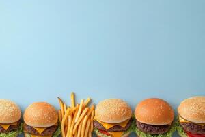 Delicious burgers arranged with crispy fries on a vibrant blue background photo