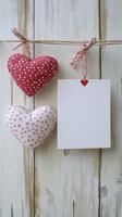 Creative display of handmade heart decorations with a blank note on a rustic wooden background photo