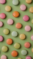 Colorful macarons arranged on a green background showcasing various pastel shades photo