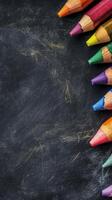 Crayons arranged on a chalkboard surface in vibrant colors for creative activities photo