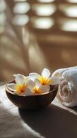 Spa setting with tropical flowers in wooden bowl and soft towels for relaxation photo