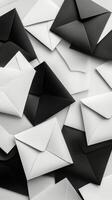 Various black and white envelopes arranged in a chaotic pattern on a flat surface photo