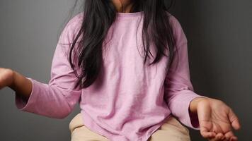 A Playful Child Delightfully Posing with Hands While Wearing a Pink Top video