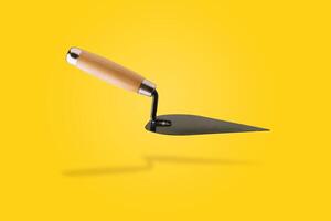 Triangle trowel over yellow photo