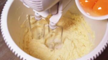 Whipping butter and sugar to perfection with egg yolks in slow motion video