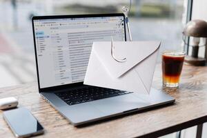 Notification message spam on hook, virus concept. Mail came to laptop from display. Phishing, creative idea. Personal data theft. Mailing and marketing. Phishing and hacker attack via email. photo