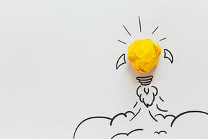 Idea light bulb crumpled yellow paper ship take off to the sky like a rocket. Business, Startup and Development, Concept. Think Different, Creative Idea. Dream come true photo
