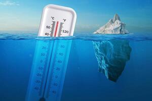 Iceberg in clear blue water and hidden danger under water. Global Warming Concept. Floating ice and a thermometer with a high temperature in ocean. Abnormal heat, concept. Warming, creative idea photo
