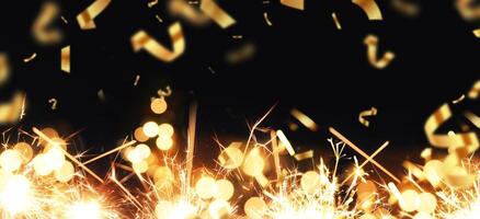 Black festive background with gold confetti, bokeh light and sparks. New Year card. Free copy space for design and text photo