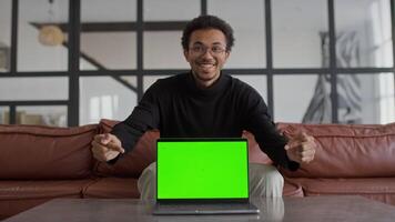 Man Smiling with Laptop Displaying Green Screen in Modern Living Room video