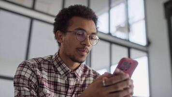 Smiling Man Texting on Smartphone in a Modern Office video