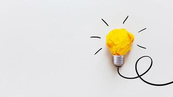 Yellow crumpled paper light bulb drawn on a white background. Brainstorm and creative idea, concept. Project and startup. Business and growth photo
