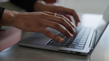 Close-up of hands typing on laptop keyboard in modern workspace video