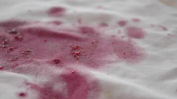 There is a spill of red wine on the white fabric, creating a noticeable stain video