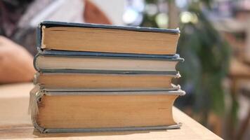 un abierto libro con sus paginas suavemente torneado descansa en un de madera mesa en el brisa video