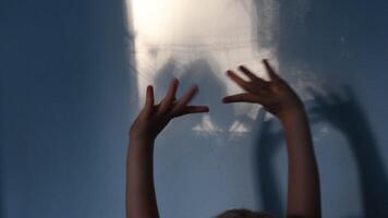 Blur shadows of child hands on wall. Game with light and shadow. Dark spooky silhouettes of hands for Halloween concept video