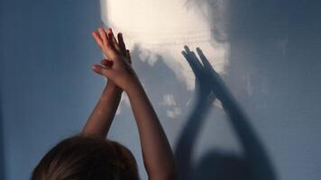 Blur shadows of child hands on wall. Game with light and shadow. Defocus spooky silhouettes of hands for Halloween concept video