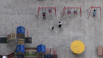 oben Aussicht von Kinder Spielplatz mit unkenntlich Menschen und Kinder im ziehen um schwingt. Antenne Aussicht zu Spielplatz Ausrüstung. Odessa, Ukraine, 11 04 2020 video