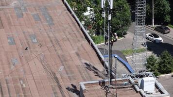 Mountaineering construction works on telecommunication tower. Unrecognizable workers hanging on top and fixing radio unit on communication tower video