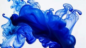 Abstract shapes formed by blue and teal ink blending ink in water on a white background video