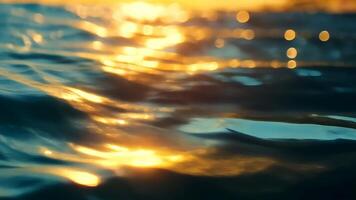 Golden sunset light reflecting on a gently moving water surface, creating beautiful bokeh and highlights background video