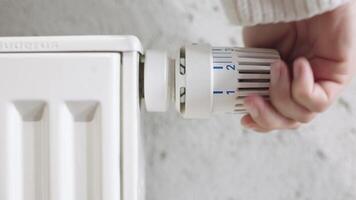 a mulher voltas fora a aquecimento de configuração a termostato do a central aquecimento radiador para a mínimo modo do mantendo a temperatura dentro a quarto video