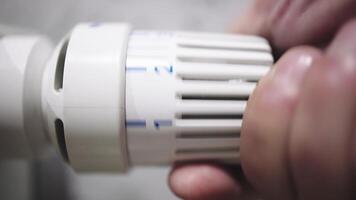 temperatura em uma radiador termostato, regulador casa aquecimento para energia eficiência. mão ajustando temperatura em termostato para ao controle calor dentro central casa aquecimento sistema. casa dentro inverno conceito. video