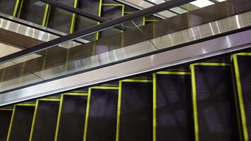 A modern escalator moving upwards in a sleek architectural setting. This shot captures the clean lines and reflective surfaces, perfect for concepts of urban life, transport, or technology. video