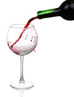 Red wine pouring on white background photo