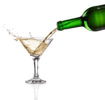 White wine pouring from the bottle intro the glass on white background photo