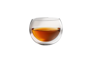 Unique glass bowl filled with amber liquid sits elegantly on a table against a minimalist background during evening light png