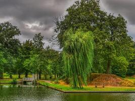 A pond with a bench and trees in the background photo
