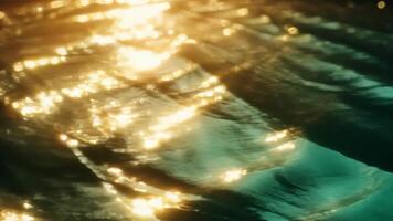 Golden sunset light reflecting on a gently moving water surface, creating beautiful bokeh and highlights background video