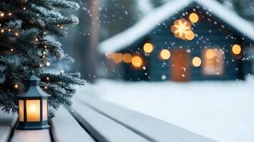 Snow dusted balcony with small christmas tree and flashlight lit lantern, blurred chalet and festive lights candle in background video