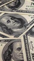 Background with One Hundred Dollar Bills on a Rotating Platform. Stack of cash. Close-up, Vertical footage video