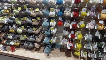 KYIV, UKRAINE - DEC 22, 2024. Rows of ceramic cups in various colors and designs fill the shelves of a retail store, showcasing a vibrant assortment for potential customers to browse and select. video