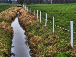 A fence with a stream running through it and a white fence photo