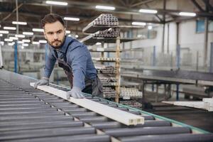 Factory worker handling pvc window frame on production line photo
