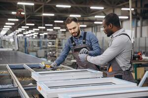 Factory workers assembling pvc window frames on production line photo