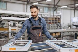 Factory worker assembling pvc windows in production line photo