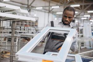 Factory worker assembling aluminum window frame in production line photo