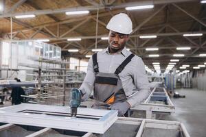 Factory worker assembling pvc window frame using electric screwdriver photo