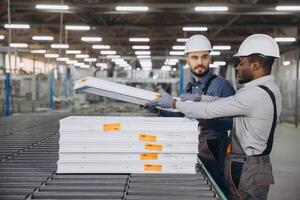 Factory workers handling pvc window frames on production line photo
