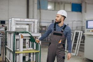 Factory worker transporting pvc window frames on a trolley photo