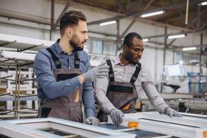 Factory workers assembling aluminum and pvc window frames in workshop photo