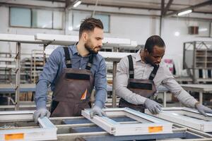 Factory workers assembling pvc windows in production line photo