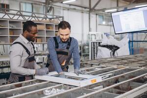 Factory workers assembling aluminum window frame in production line photo