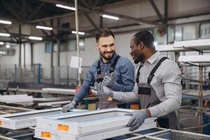 Factory workers assembling PVC windows in production line photo
