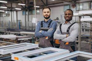 Factory workers posing with arms crossed near pvc window frames photo