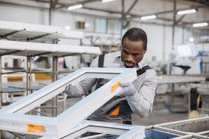 Factory worker assembling pvc window frames in production line photo